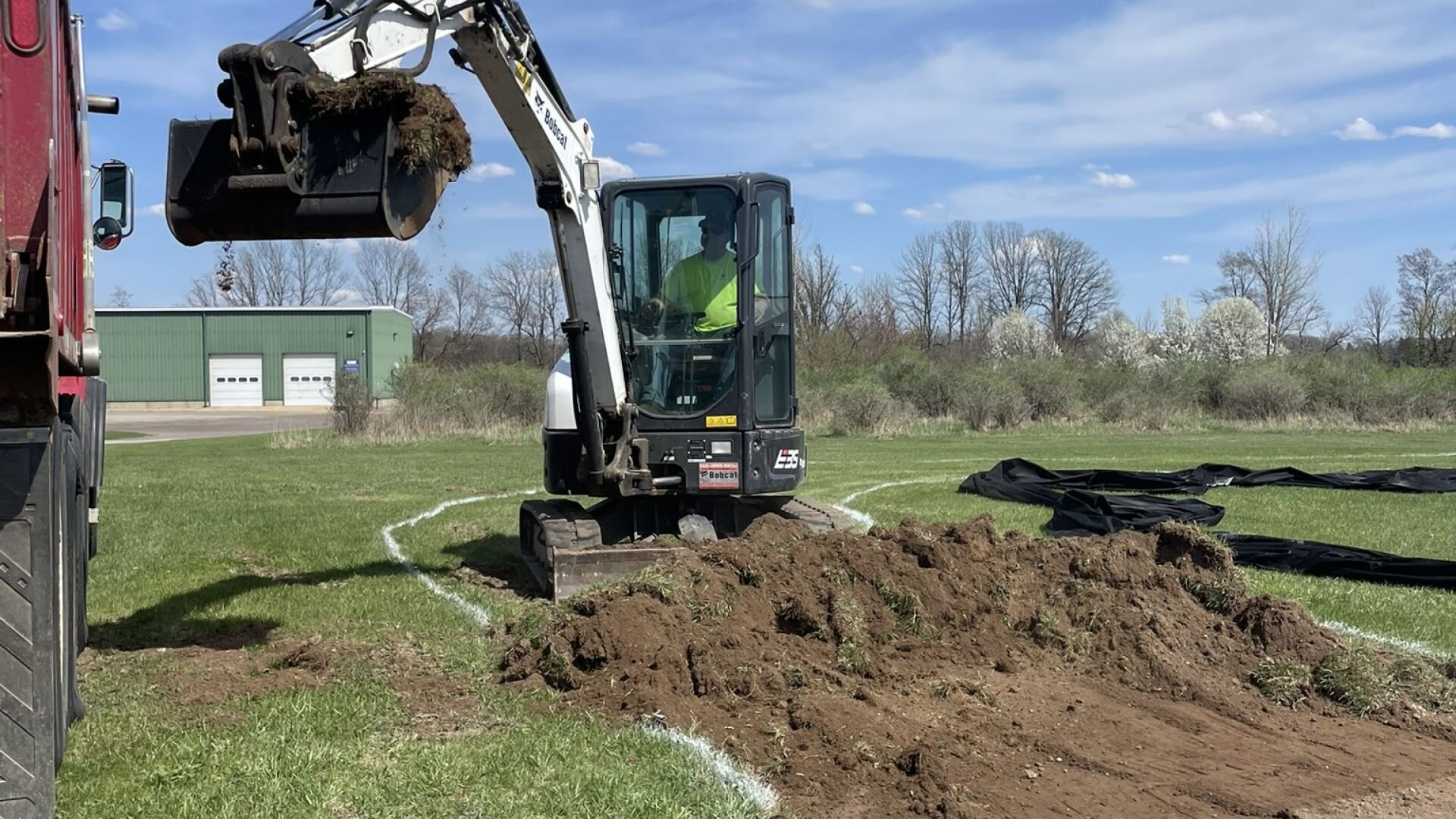 Bobcat E35 excavator working on grass field jobsite — Mason, MI